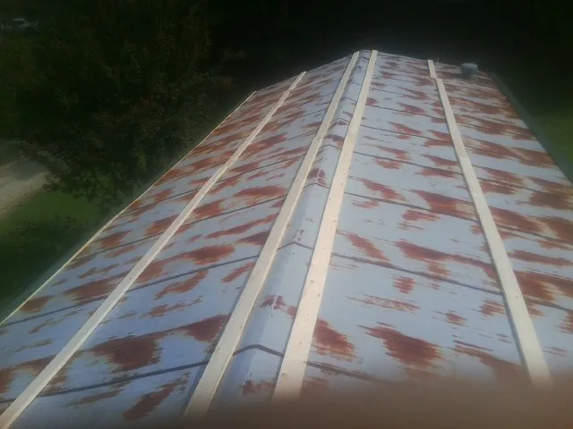 Rusted metal roof panels with new wood purlins before replacement — Storm Damage Roof Repair in Woodburn by Roofing Brothers