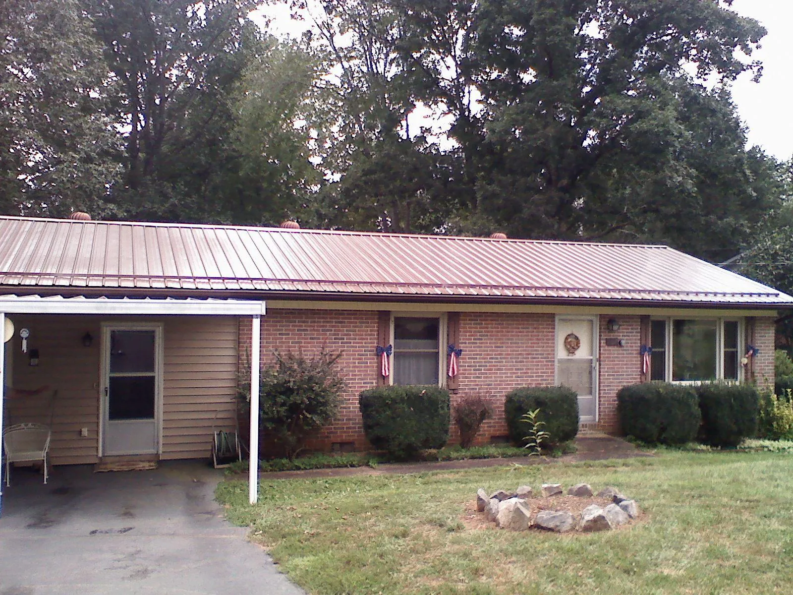 Bronze metal roof and carport on a brick ranch home — Roof Repair work by our crew in Woodburn